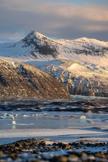 Captivating view of Iceland's snowy mountains, icy beaches, and ethereal landscapes at sunset in