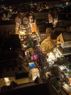 Crowd at a lively Christmas market in an illuminated city street, Christmas market Calw, Black