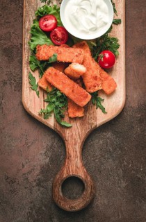 Fried fish nuggets, with white sauce, arugula and cherry, no people