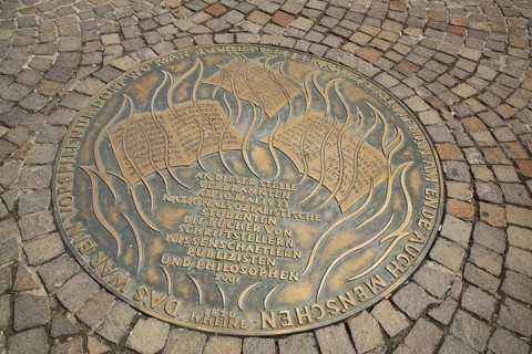 Round memorial plaque on book burning during Nazi era, destruction by flames and fire, Holocaust,