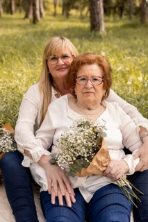 A touching scene of a mother and daughter sitting in a green park, sharing a peaceful day. They