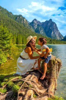 Tourists enjoying summer holidays at lake dobbiaco, surrounded by the stunning scenery of the