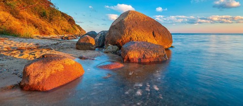 Coastal landscape with large boulders on the Baltic Sea beach in the evening light, Mönchgut Nature