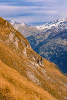 A rocky mountainside stretches across a wide valley under a slightly cloudy sky, Planplatten,