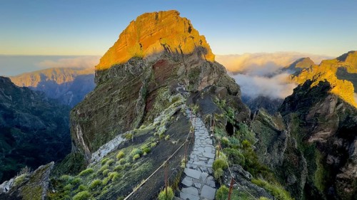 Sunrise at Pico do Arieiro, clouds of fog pass over mountain peaks, hiking trail PR1, Madeira,