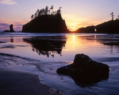 A dramatic sunset silhouettes a sea stack at Second Beach in Olympic National Park, Washington