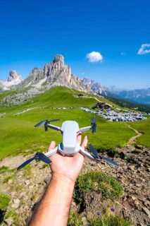 Hand holding a drone ready to fly over the beautiful landscape of passo giau in the italian