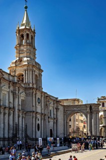 Bustling scene in front of an impressive church tower and historical background under blue skies,