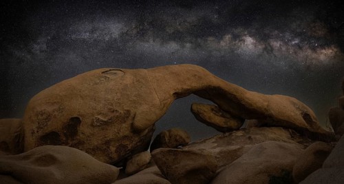 A stunning long exposure of Joshua Tree National Park's vast desert, showcasing the Milky Way