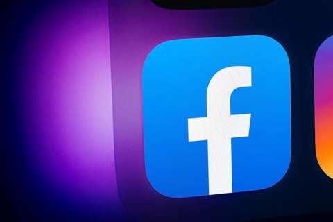 A close up of an iPad screen displaying the facebook app icon
