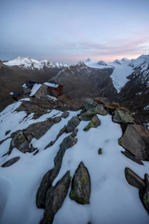 Snow-covered mountain landscape, mountain hut Ramolhaus in autumn with snow, at sunset, view of