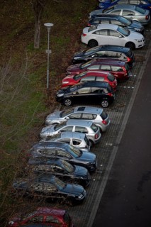 Row of parked cars in a car park next to a road, Magdeburg, Saxony-Anhalt, Germany
