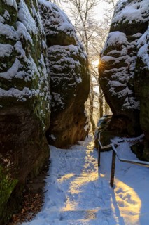 Snow-covered hiking trail between rocks in the morning sun, Bastei, Saxon Switzerland, Saxony,