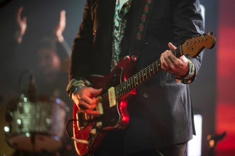 An electric guitar in the hands of a guitarist during a concert