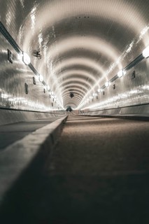 Long tiled tunnel with a perspective that emphasises the continuous lighting, old Elbe tunnel,