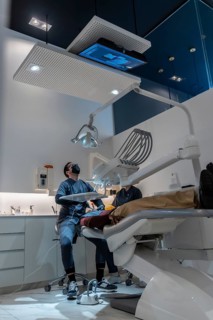 Dentist examining patient's teeth in modern dental clinic, using advanced equipment and technology
