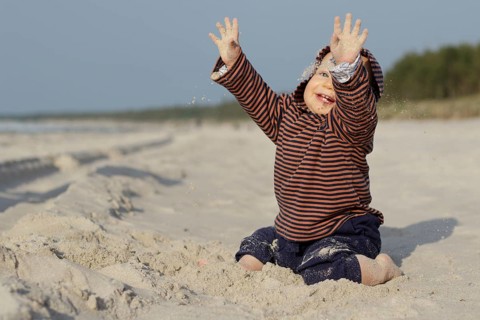 Child playing on the sandy beach. Pobierowo, Poland