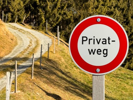 Prohibition sign, private road sign next to a dirt road in the mountains, Tyrol, Austria