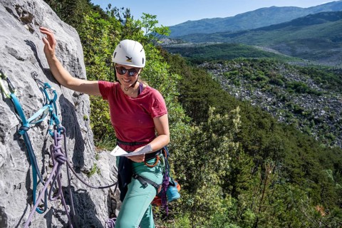 Climber on the rope looking at the topo, multi-pitch climbing, Via la Bellezza della Venere, Garda