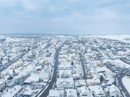 Aerial view of a snow-covered town, streets and roofs clearly visible, Deckenpfronn, Böblingen