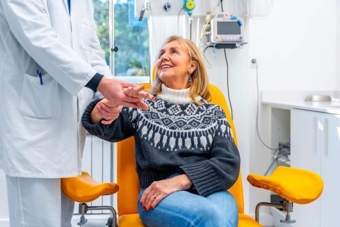 Doctor inspecting the hand of a mature woman in emergency room