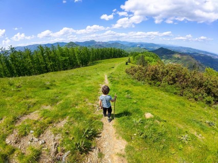 Child walking on a mountain path enjoying the landscape of mount aldura in errenteria, gipuzkoa