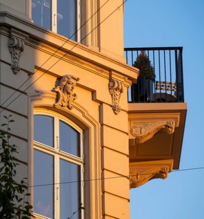 A building in warm evening light with decorative façade elements and balcony, Frederiksberg,