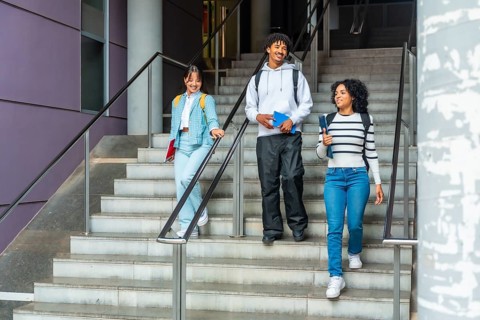 Students walking down stairs talking relaxed outside the university campus
