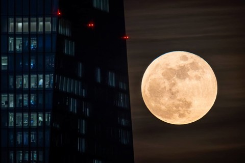 The moon passes behind the European Central Bank (ECB) in Frankfurt am Main. The full moon in March
