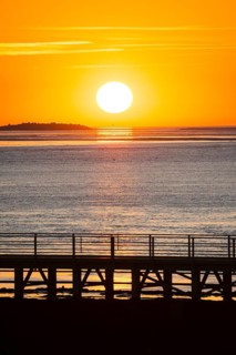 Silhouette of a jetty, pier free canal, in front of a picturesque, golden, breathtakingly beautiful