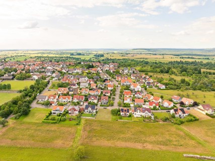 Town view with many houses in a residential area, surrounded by fields and under a slightly cloudy