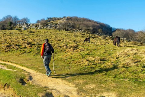 A man walking on the path climbing to the top of Mount Ernio or Hernio in Gipuzkoa, Basque Country