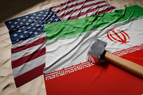 Large hammer, american and Iranian flags resting on desert sand