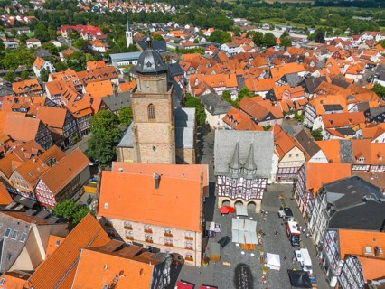 Aerial view of the centre of a historic town with red tiled roofs, half-timbered houses and a