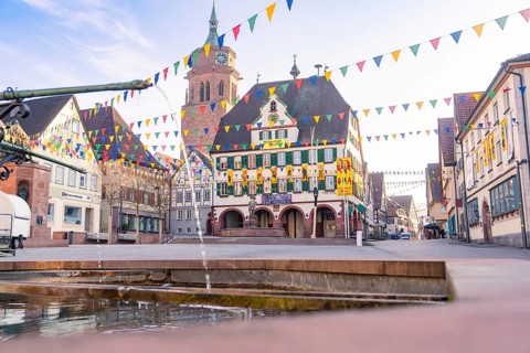 Festively decorated square with bell tower and historical charm under a clear sky, Fasnet, Weil der