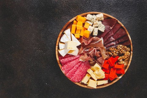 Assortment of cheese meat cuts, on a plate, top view, no people