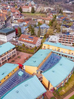 View over colourful roofs of commercial buildings in a hilly small town with trees, Bad Liebenzell,