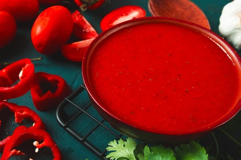 Tomato sauce, tomatoes and sweet pepper, Georgian Satsebeli sauce, with ingredients on a dark