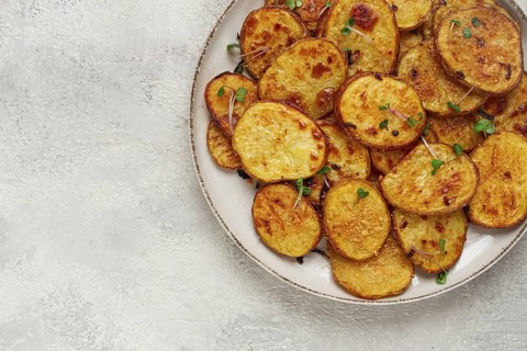 Crispy potato slices, with parmesan cheese and spices, fried in the oven, homemade, no people