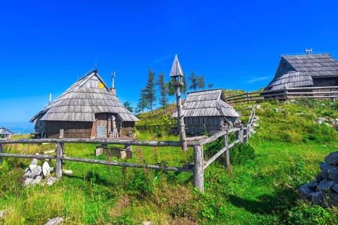 Scenic wooden houses scattered across the idyllic landscape of velika planina, overlooking the