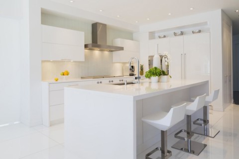 Modern kitchen with white Italian lacquered island and chrome bar stools, cabinets and countertops
