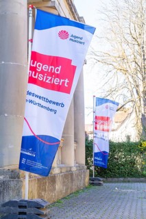 Banner with the inscription 'Jugend musiziert' attached to a pillar showing a competition