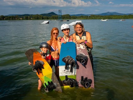 Family on summer holiday with wakeboards in the lake, water skiing and wake park, water sports,
