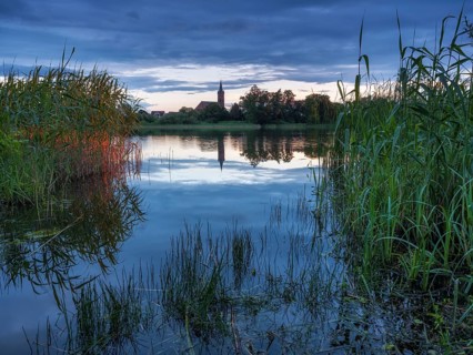 The church of Großkühnau is reflected in Lake Großkühnau at dusk, Garden Kingdom of Dessau-Wörlitz,