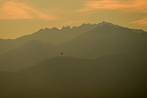 A bush plane landing against the backdrop of the Chugach Mountains, Anchorage, Alaska
