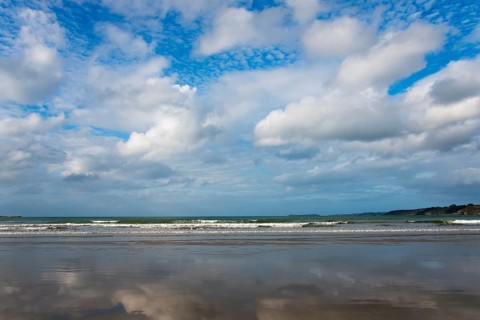 Wide coastal landscape with reflecting beach and partly cloudy sky, Plage Saint Efflamm,