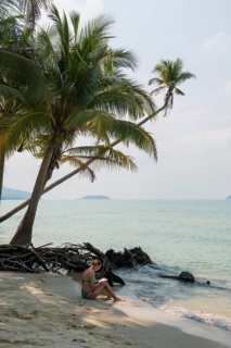 Picturesque beach with coconut palms and reading woman, Ko Chang, Koh Chang, Mu Ko Chang National