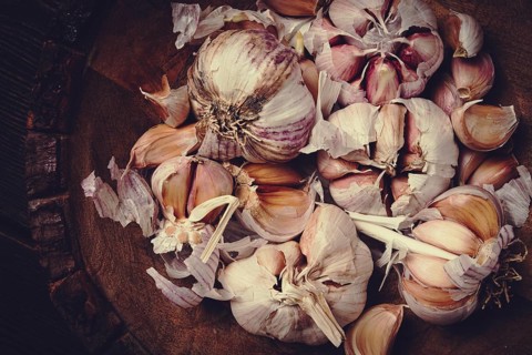 Fresh garlic, in a wooden plate, top view, close-up, no people