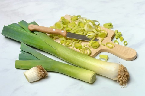Leeks, leek sticks and leek rings with wooden board