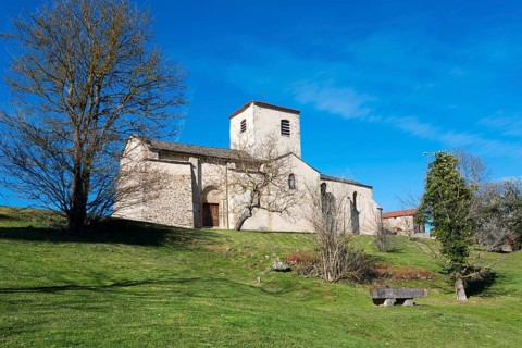 Historische Kirche auf einem mit Bäumen bewachsenen Hügel an einem sonnigen Tag, Kirche